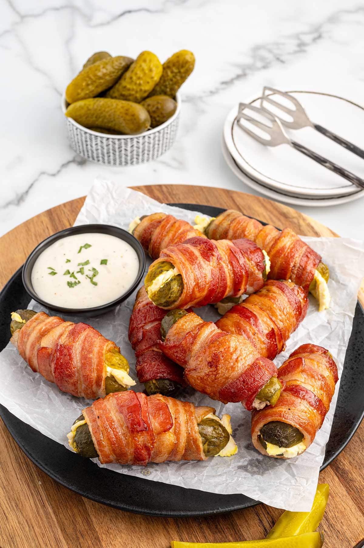 a couple of Bacon Wrapped Pickles on a plate.