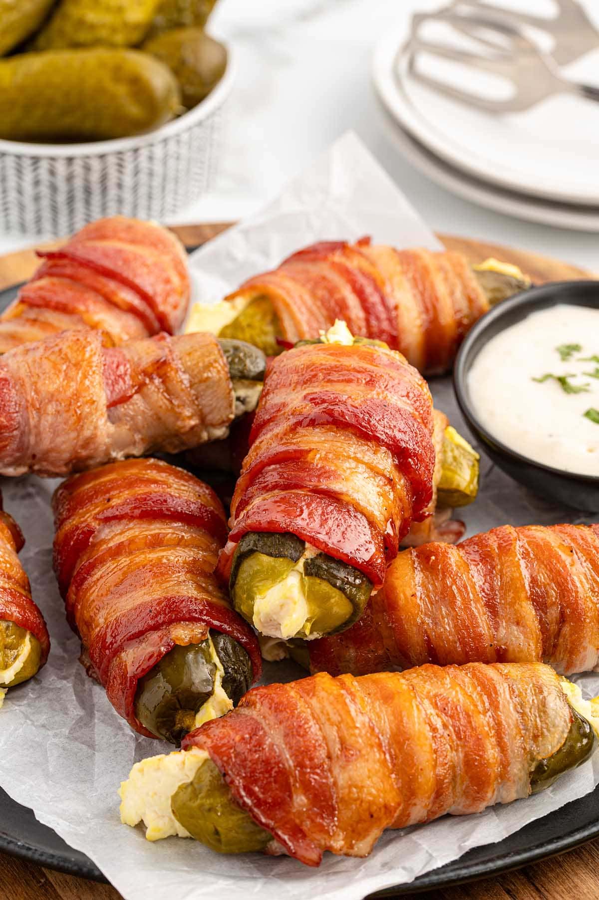 bacon wrapped pickles on top of wooden board. 