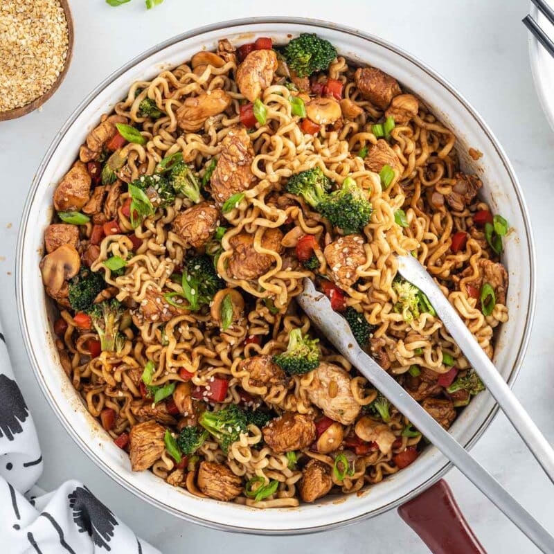 a large bowl of Chicken Ramen Stir Fry with a tong on the side.