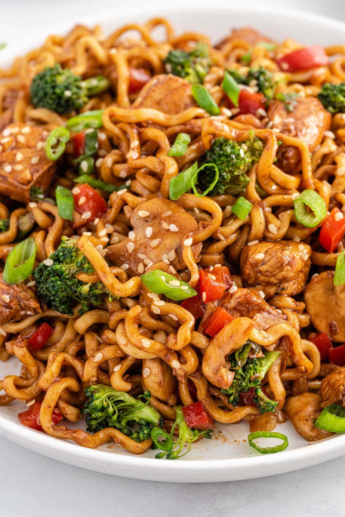 a plate of Chicken Ramen Stir Fry garnished with sesame seeds and sliced onions.