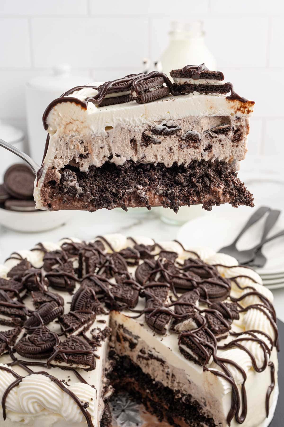 a slice of Dairy Queen Copycat Oreo Cookie Ice Cream Cake held up using a spatula.