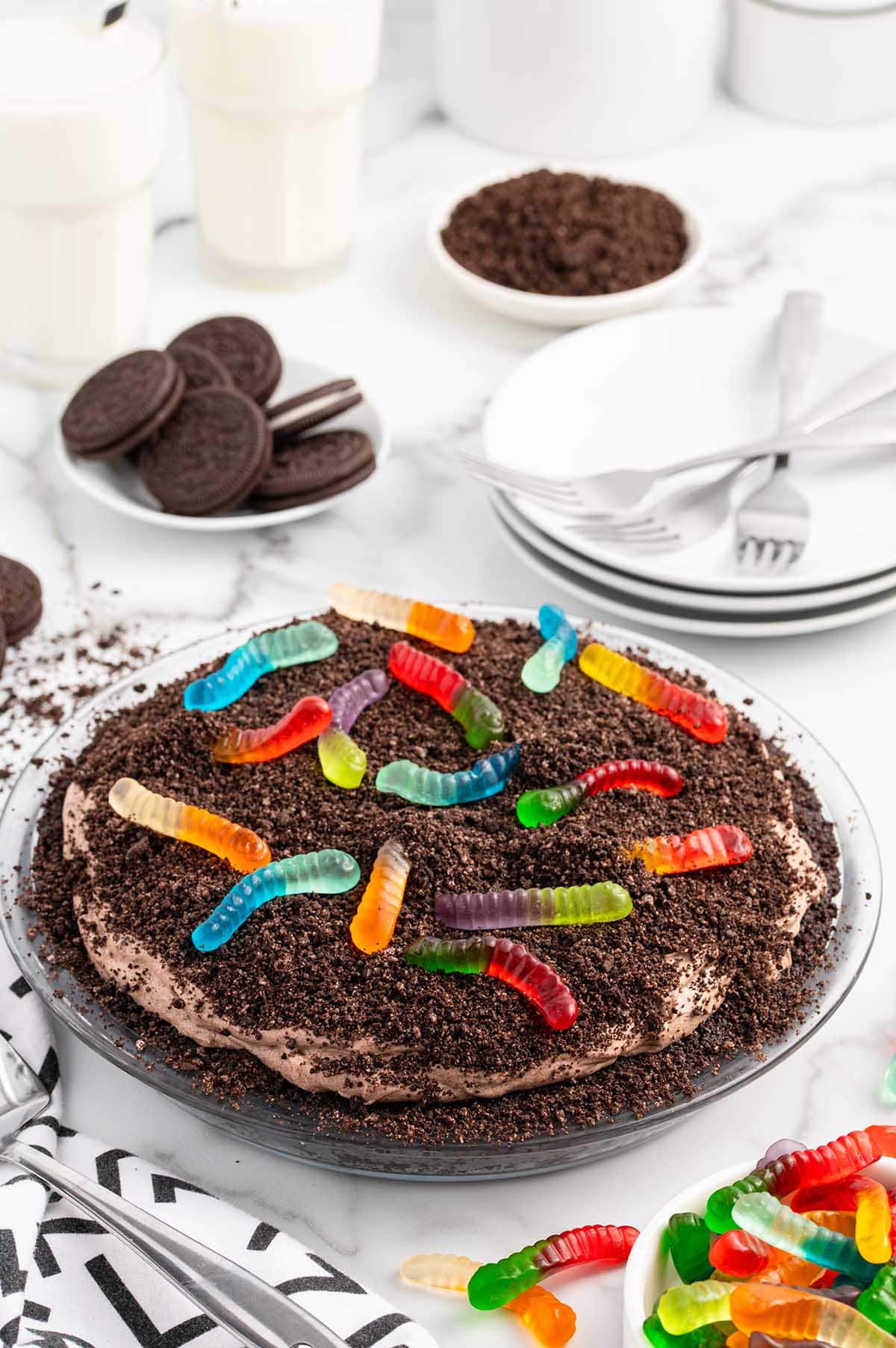 Dirt Pie on the table with oreo crumbs and gummy worms on top.