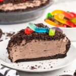 a slice of Dirt Pie on the plate with cookie crumbs topping and gummy worms.