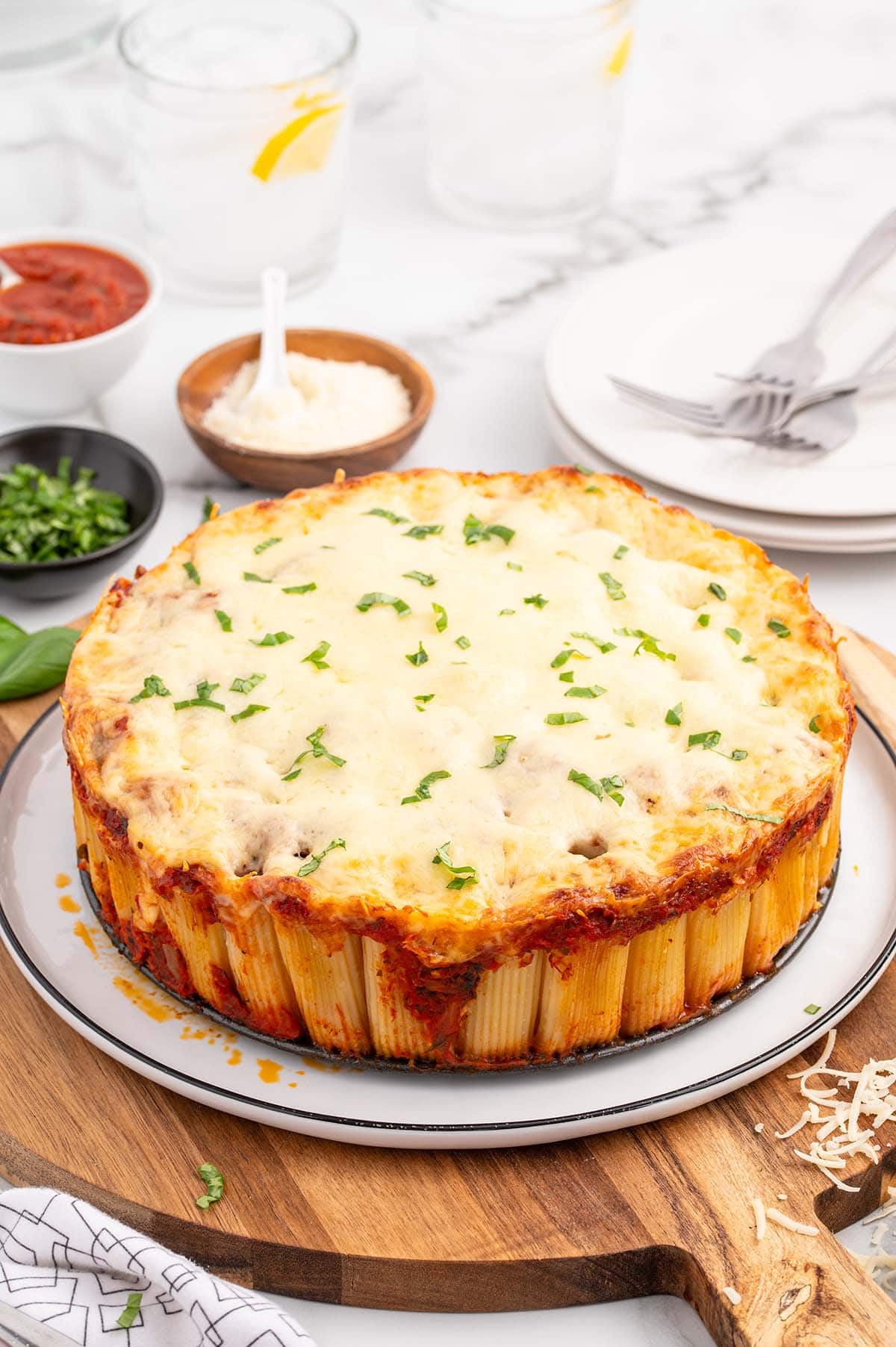 a Honeycomb Pasta Cake topped with melted cheese and garnished with chopped basil.