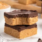 stacked peanut butter bars on top of parchment paper.