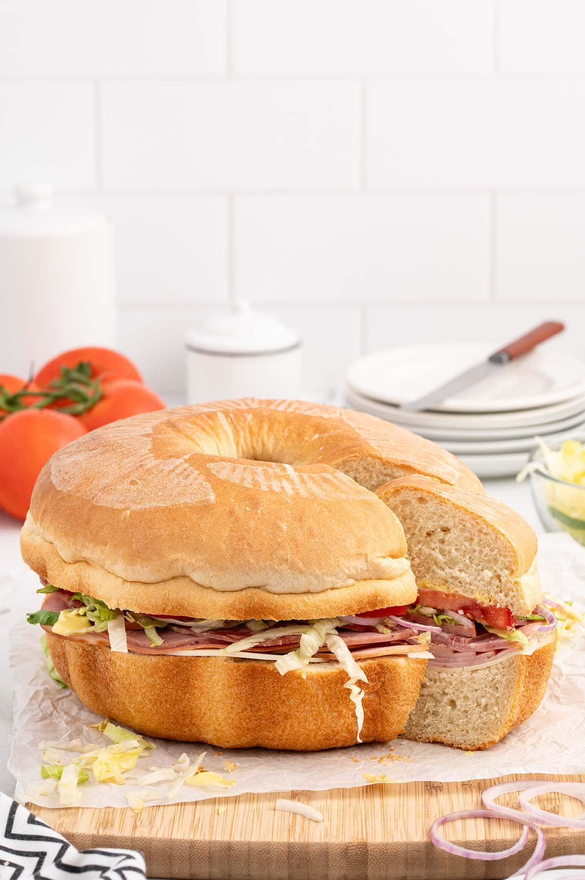 cutting a slice of party sub from wooden board. 