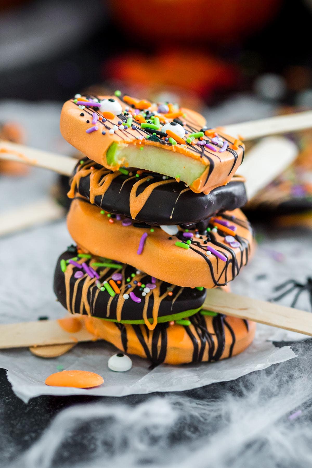 a stack of Halloween Chocolate Covered Apple Pops.