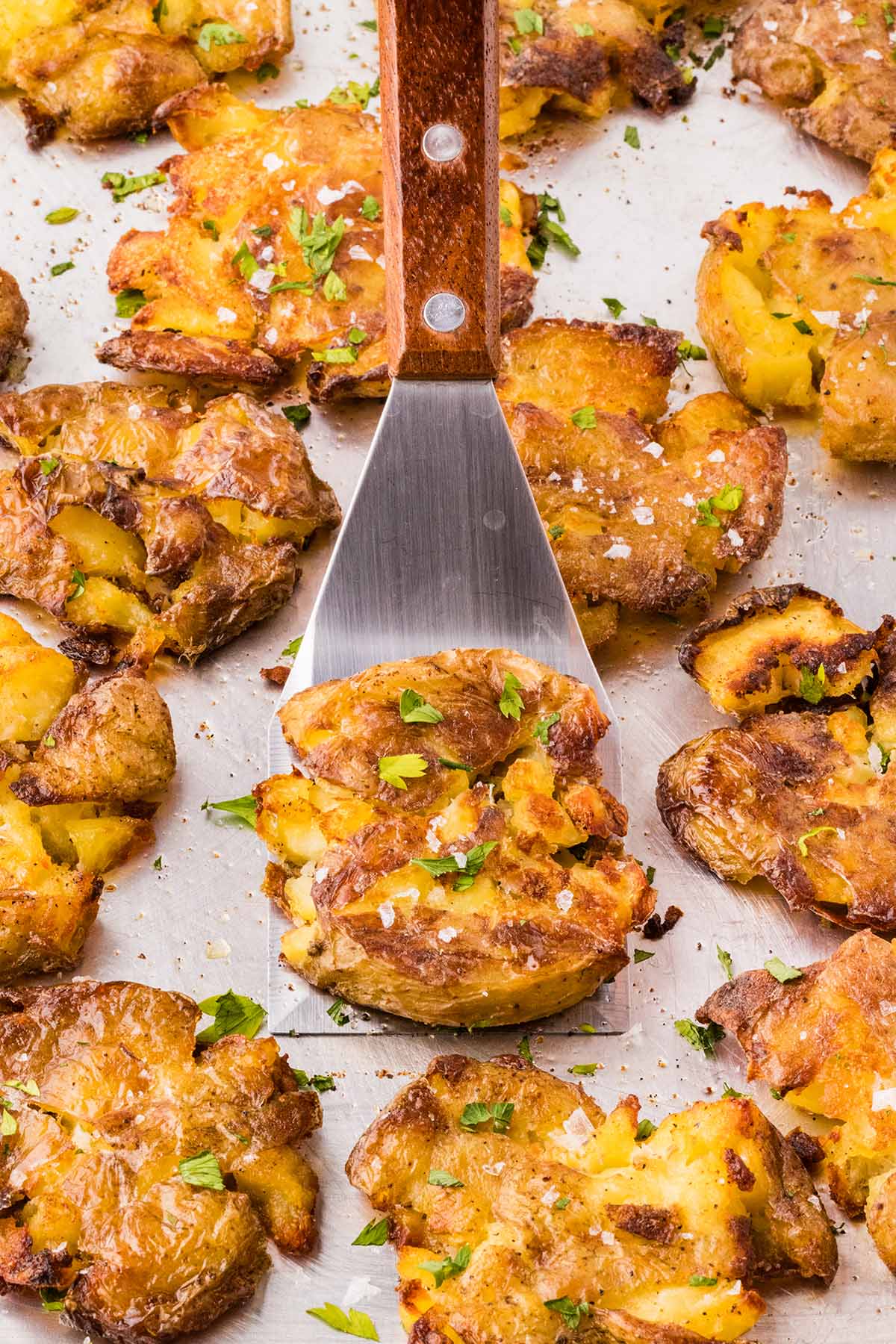 a couple of Crispy Smashed Potatoes in baking sheet. 