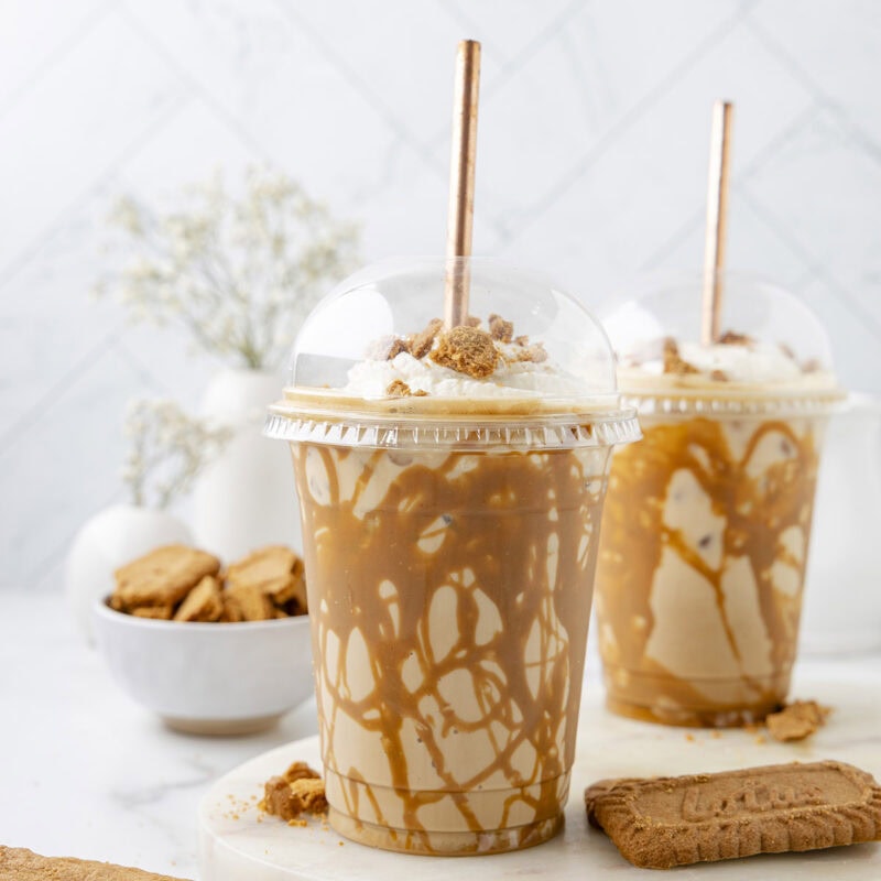 Iced Cookie Butter Latte in a plastic cups and a bowl of cookies.