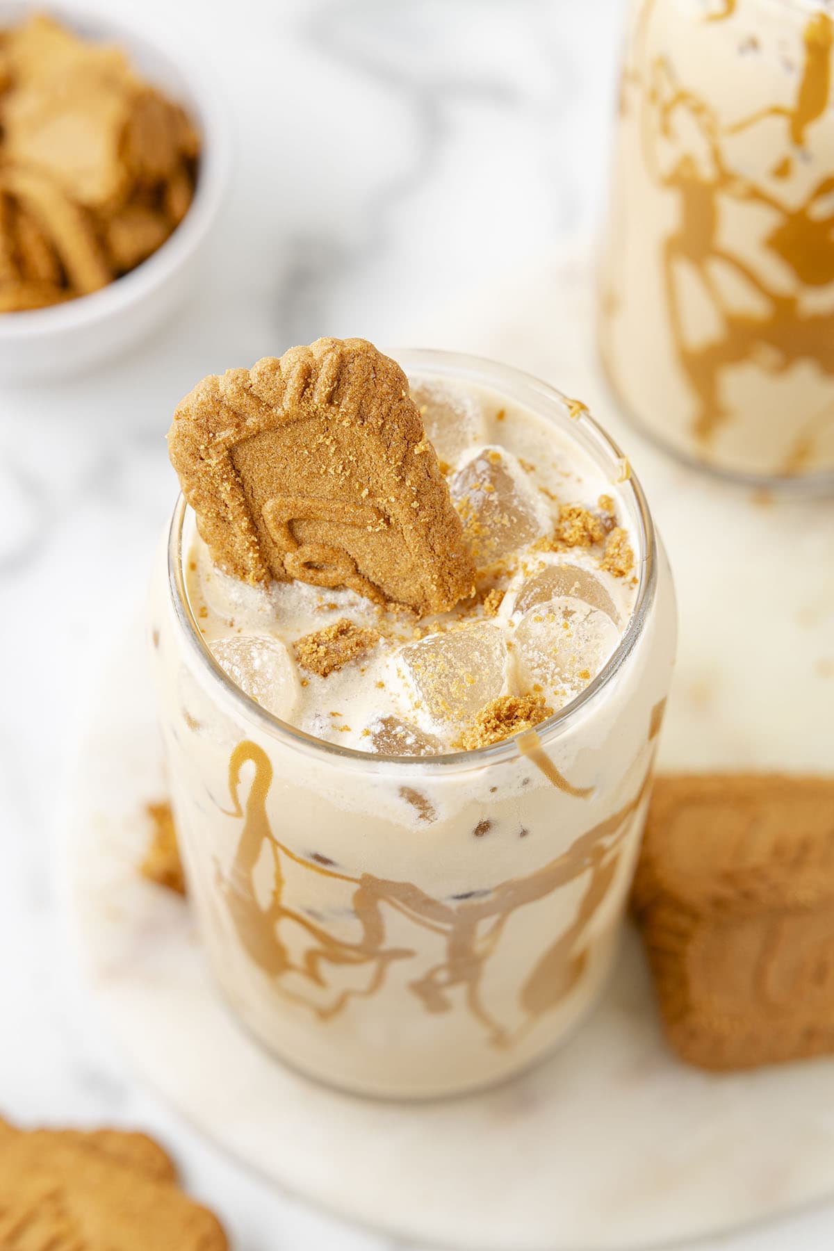 Iced Cookie Butter Latte in a clear glass and a biscoff on top.