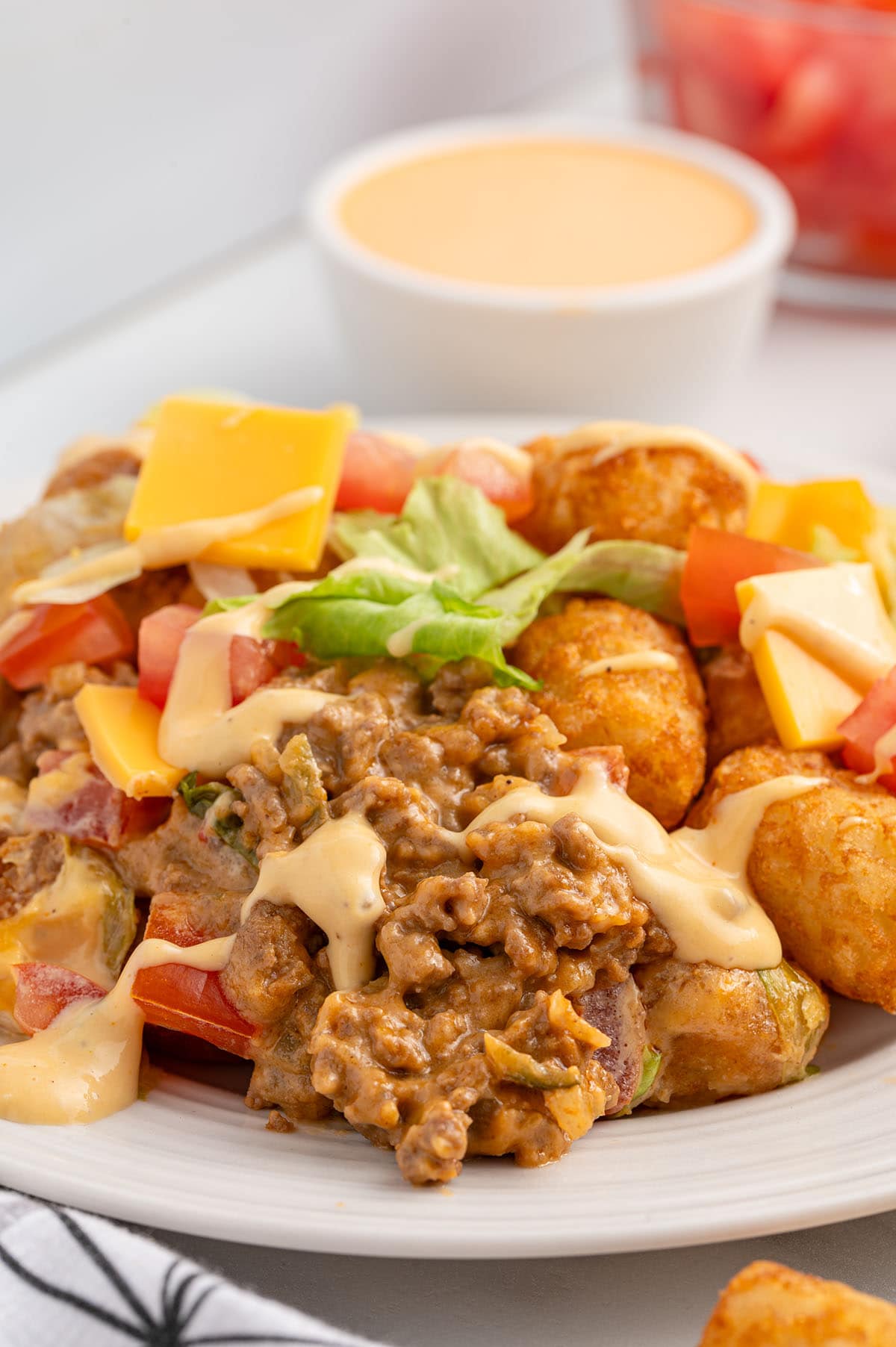 Big Mac Tater tot Casserole on a white plate drizzled with thousand island dressing.