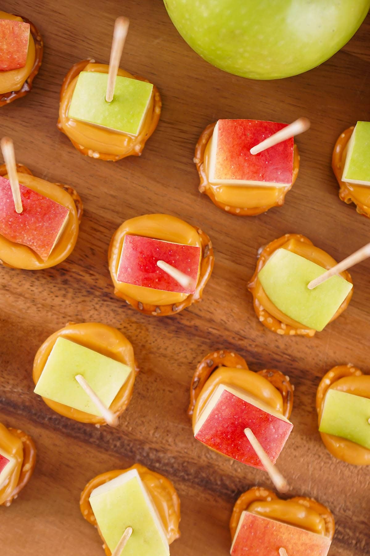 caramel apple pretzel bites on top of wooden table. 