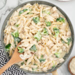 chicken and broccoli penne alfredo in a skillet.