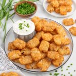 a plate of Smashed Tater Tots with a bowl of dipping sauce.