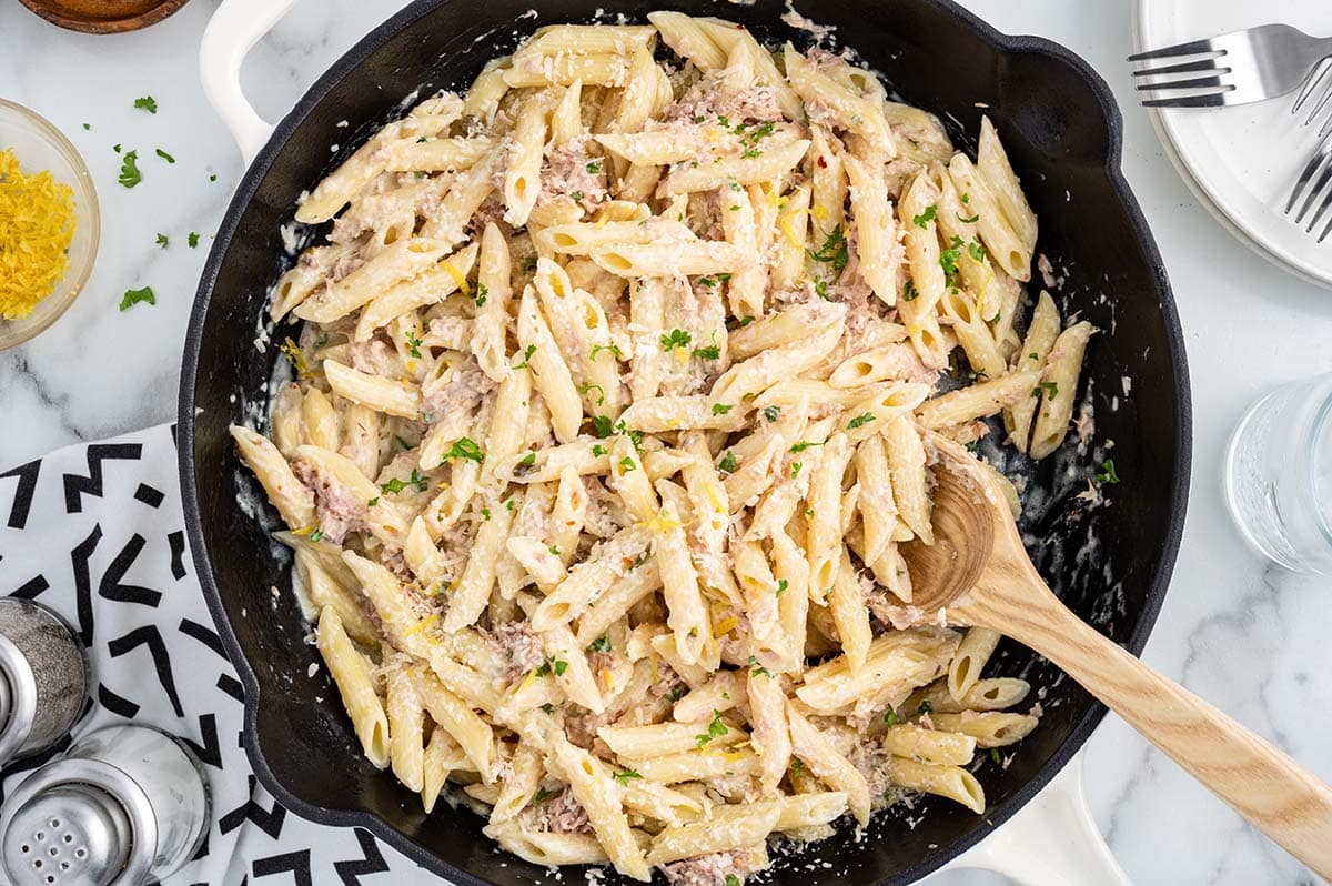 Tuna Pasta in a skillet garnished with chopped parsley.