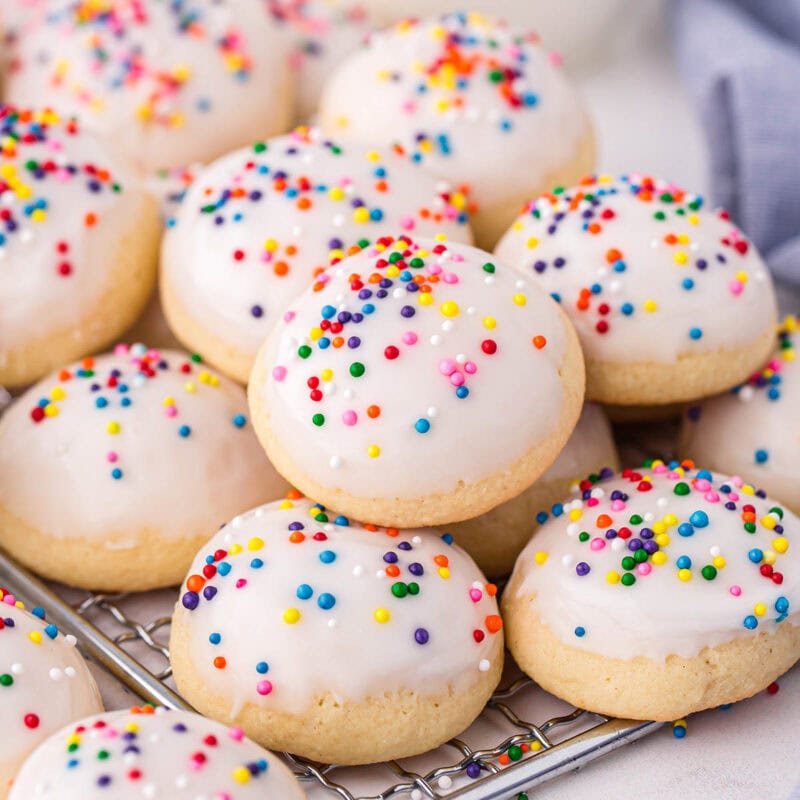 italian wedding cookies stacked on top of cooling rack.