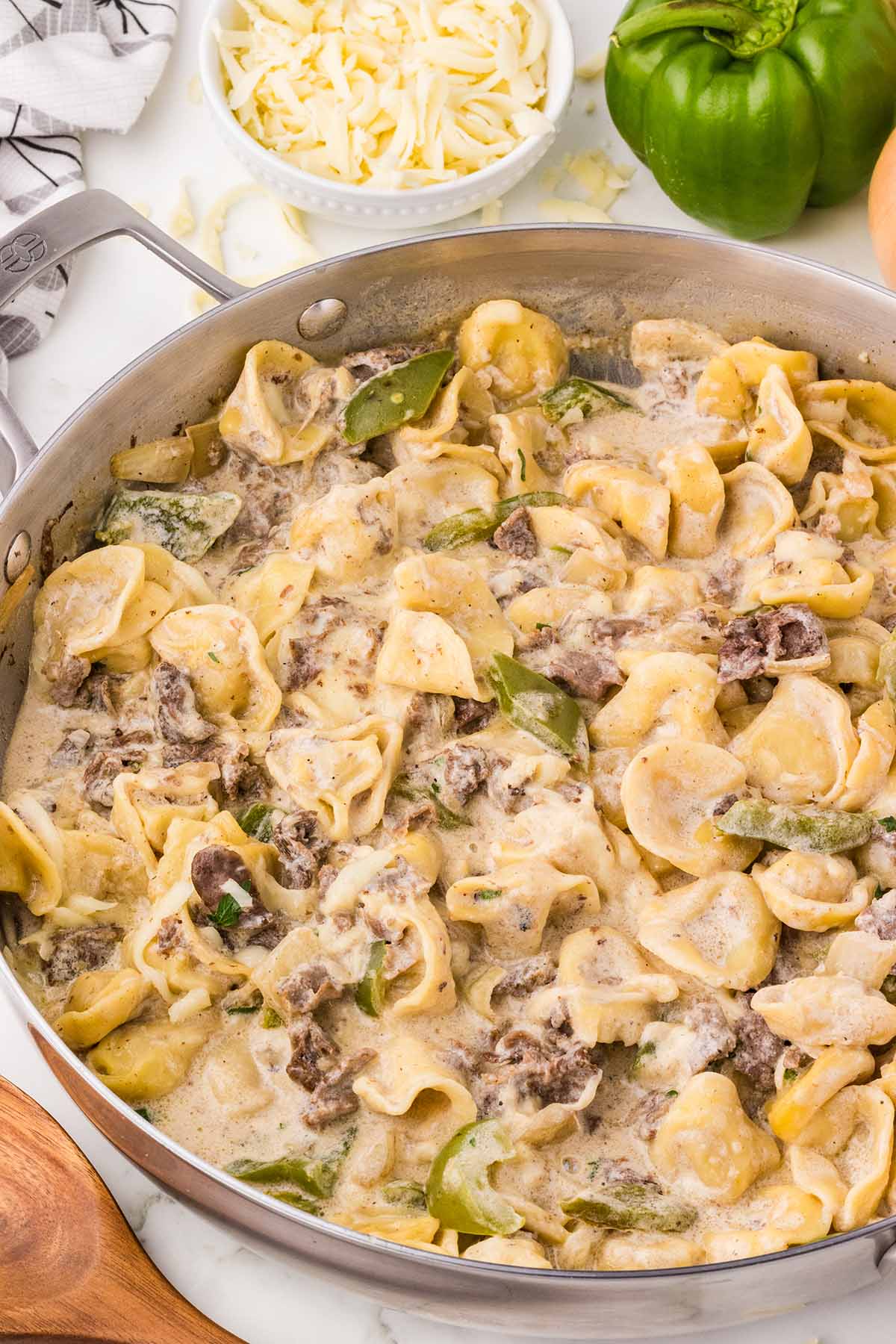 a large skillet filled with philly cheesesteak tortellini.