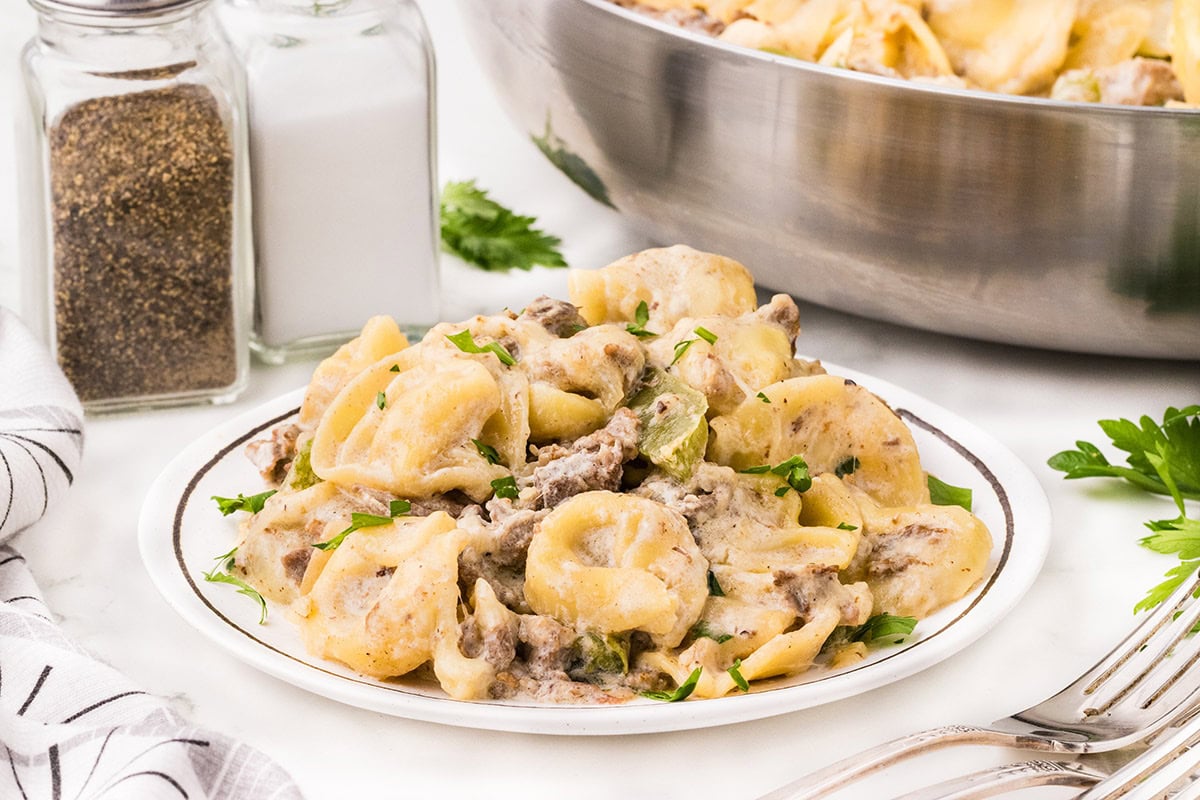 a plate of philly cheesesteak tortellini on the table.