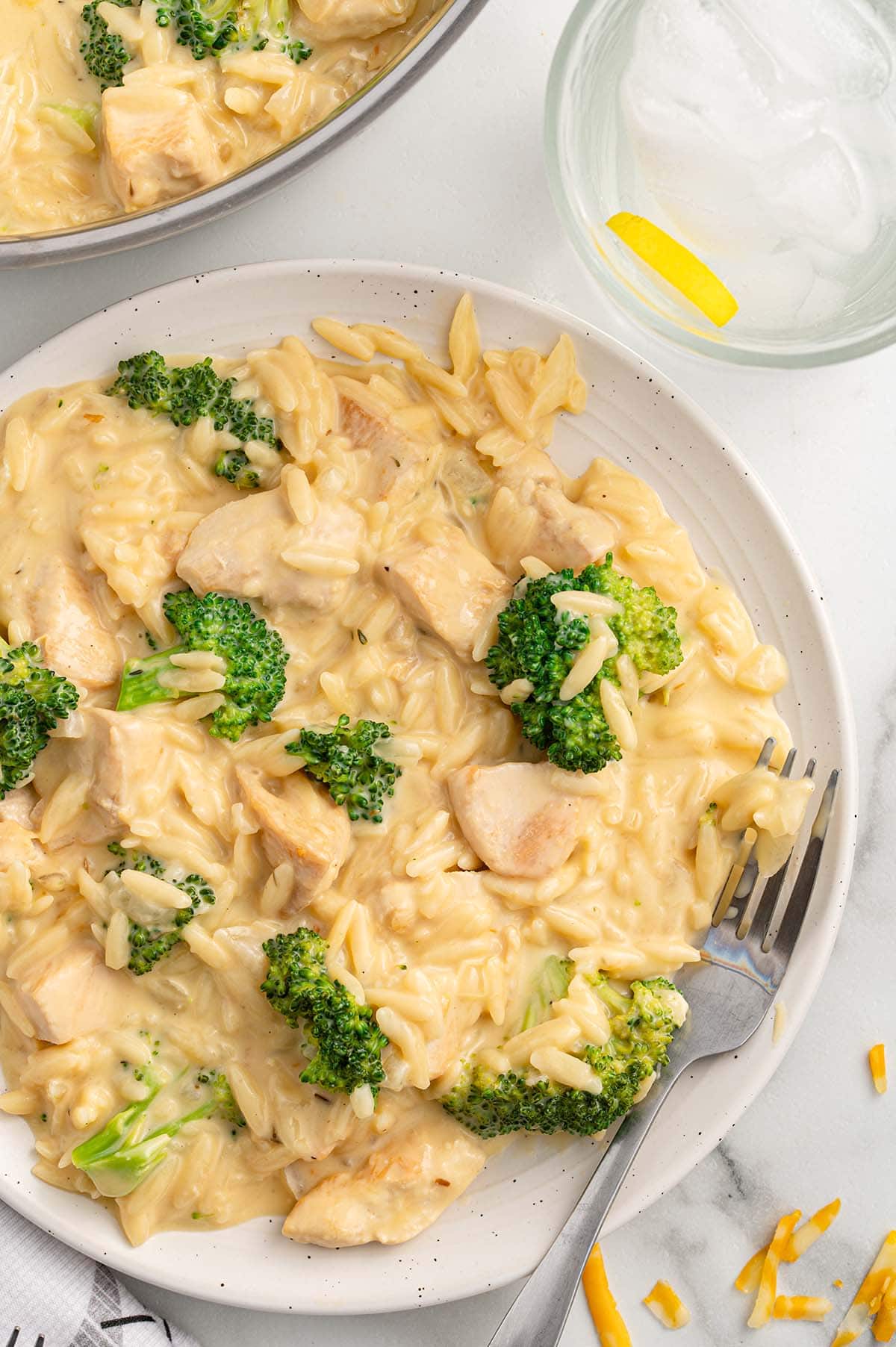 cheesy chicken orzo on a white plate.