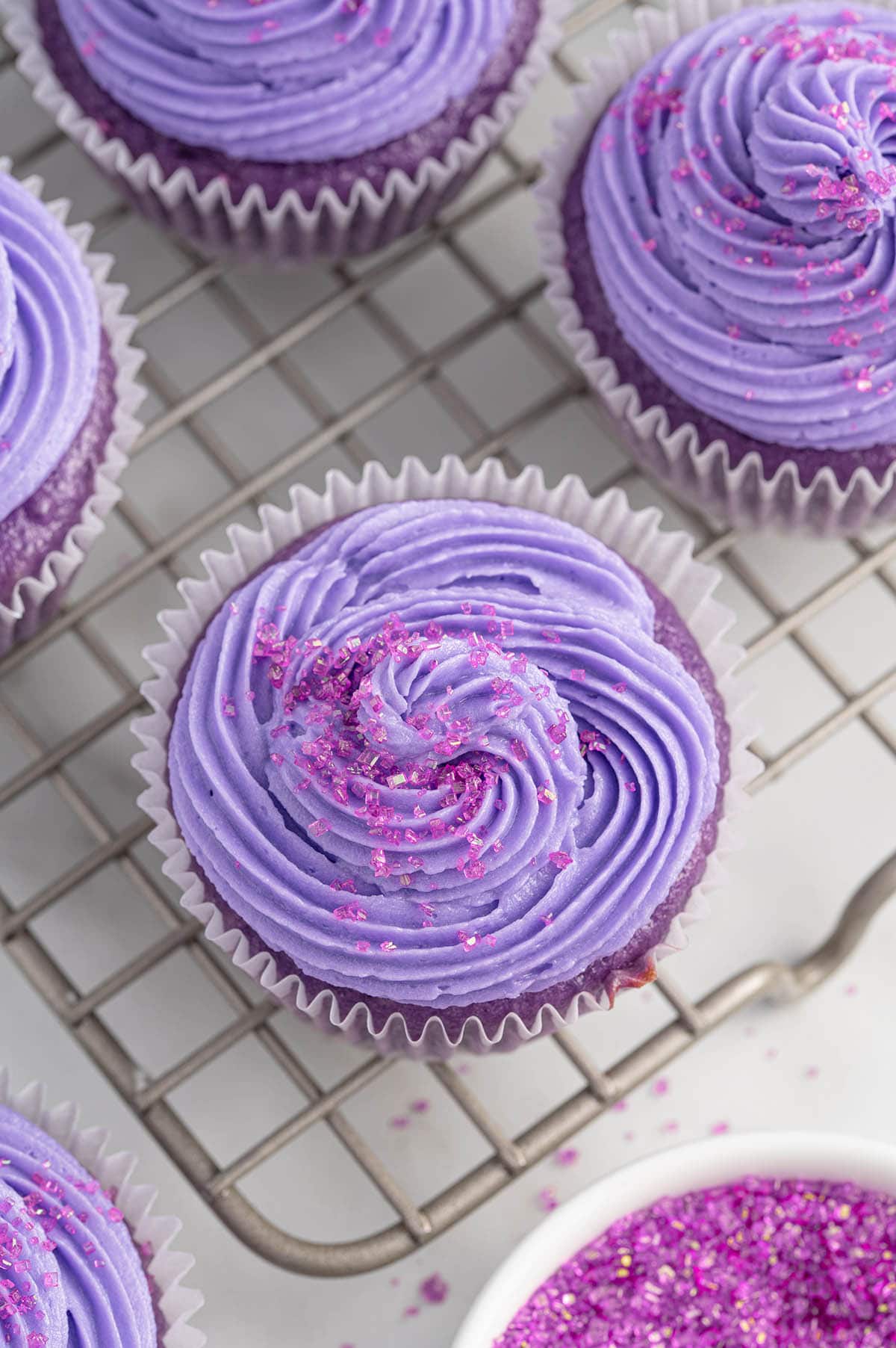 a couple of grape soda cupcakes on top of cooling rack.