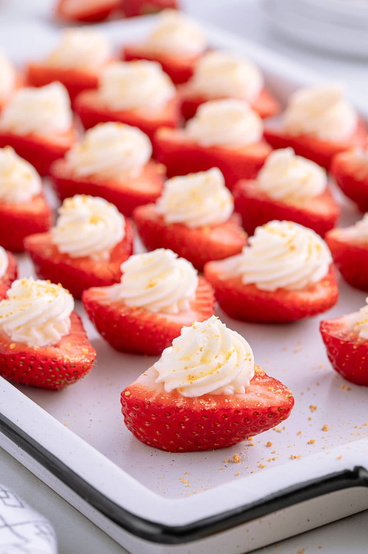 a couple of deviled strawberries with cream cheese swirled on top.