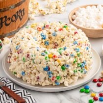 a whole popcorn cake served on a white plate.