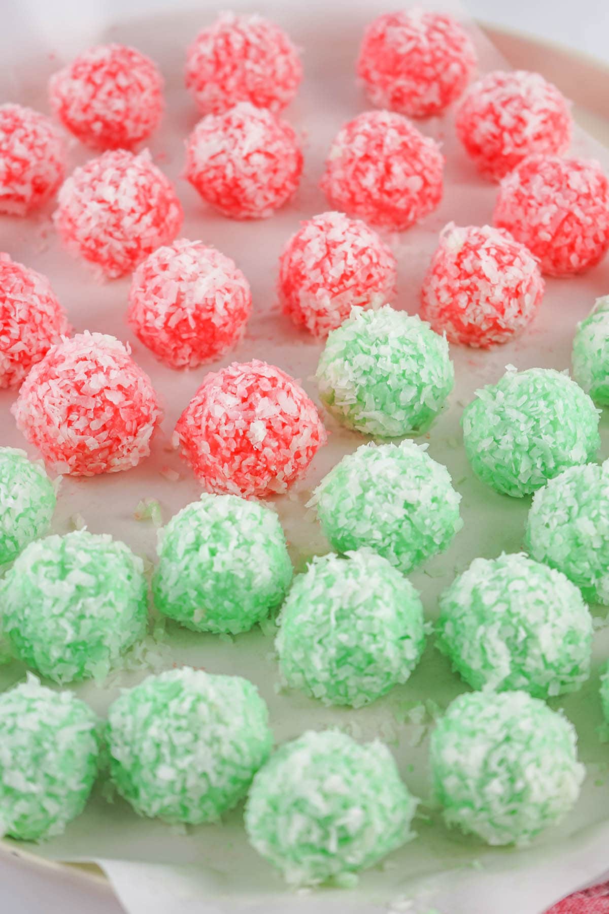 Red and green jello balls covered with coconut.