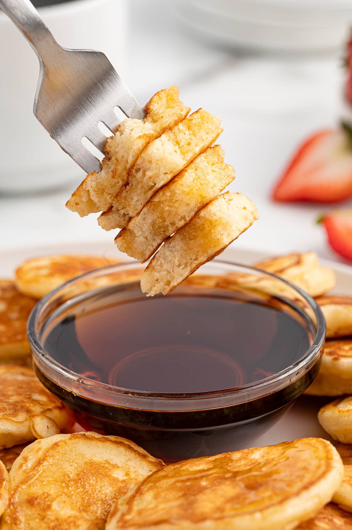 a fork holding a stack of mini pancakes.