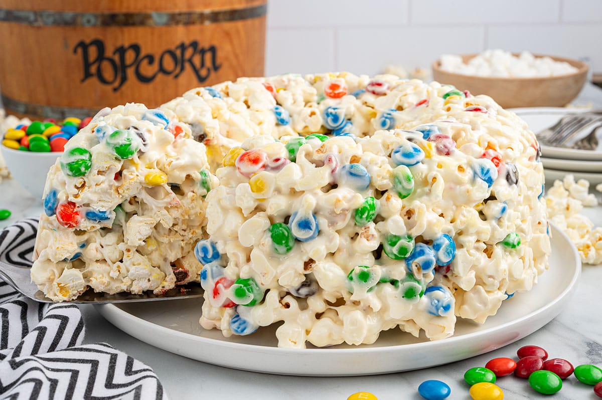 cutting a slice of popcorn cake. 