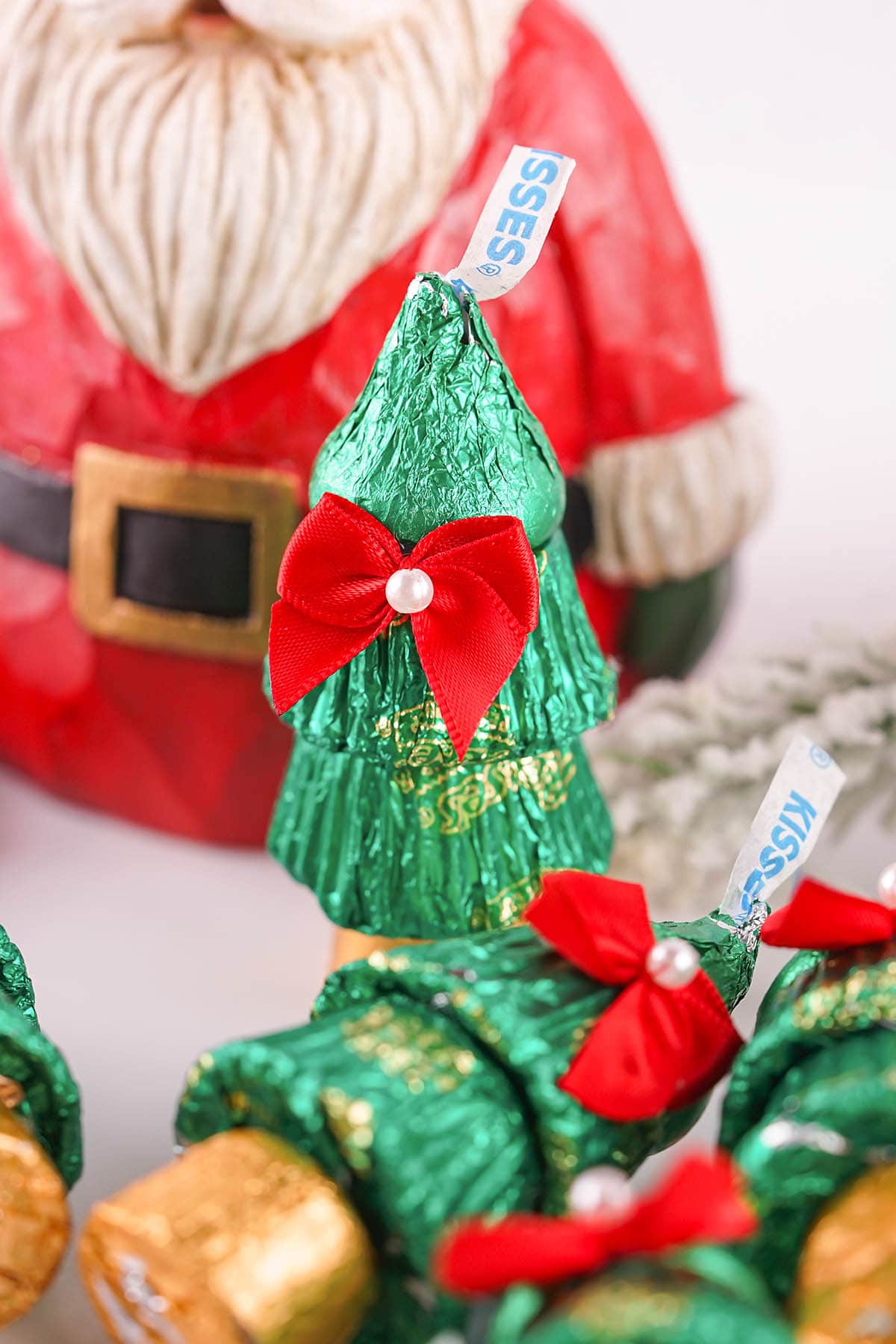 A candy Christmas tree with a Santa decoration in the background.