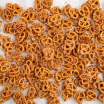 A large batch of butter toffee pretzels spread out on parchment paper.