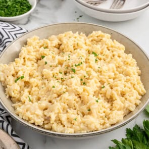 A bowl of Souper Rice, creamy and golden, garnished with fresh parsley.