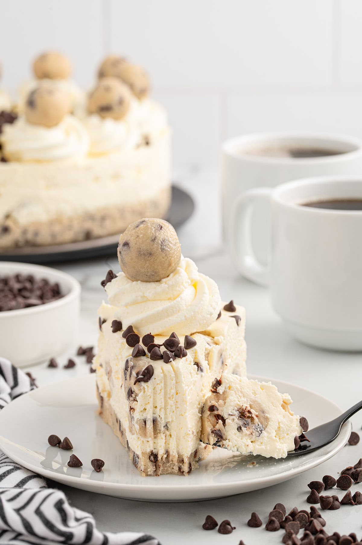 a slice of cookie dough cheesecake on a plate. 