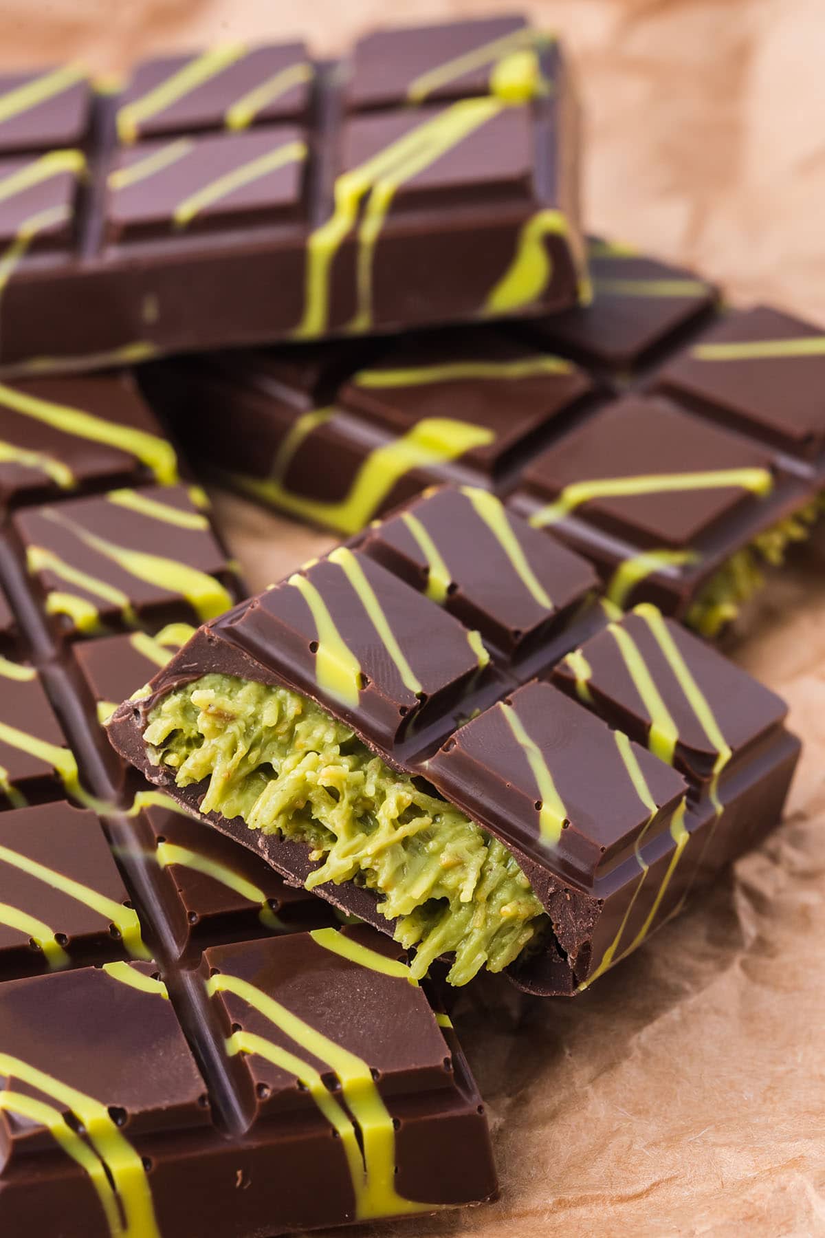 Dubai chocolate bar with green kataifi filling and yellow decorative drizzle.