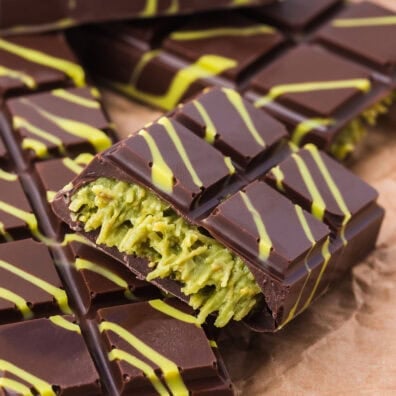 Chocolate bar filled with green kataifi pastry and decorated with yellow drizzle.