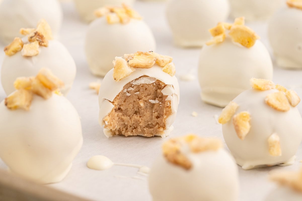 Banana Pudding Truffles arranged on parchment paper, with one truffle bitten.