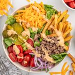 Burger bowl loaded with ground beef, fresh veggies, fries, cheese, and special sauce.