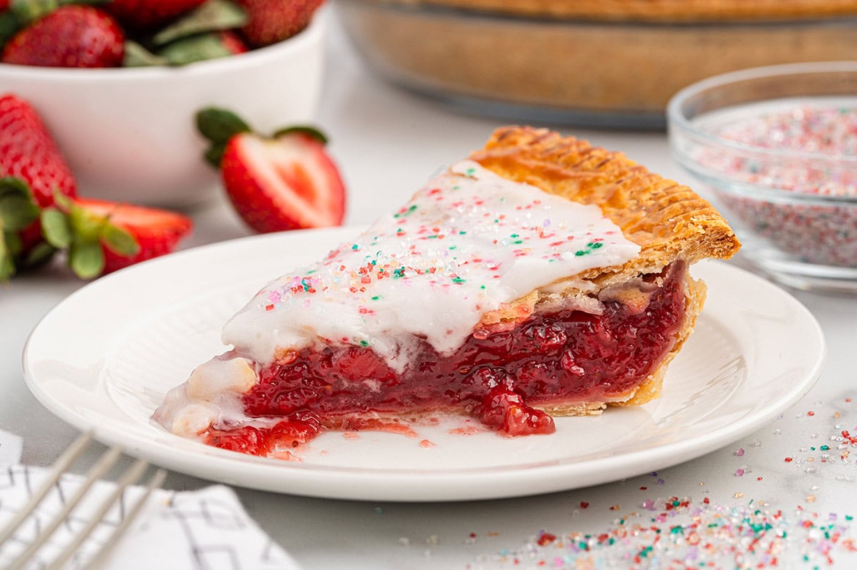 Strawberry Pop Tart Pie slice with icing and sprinkles.