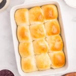 Sourdough discard dinner rolls baked to golden perfection in a white dish.