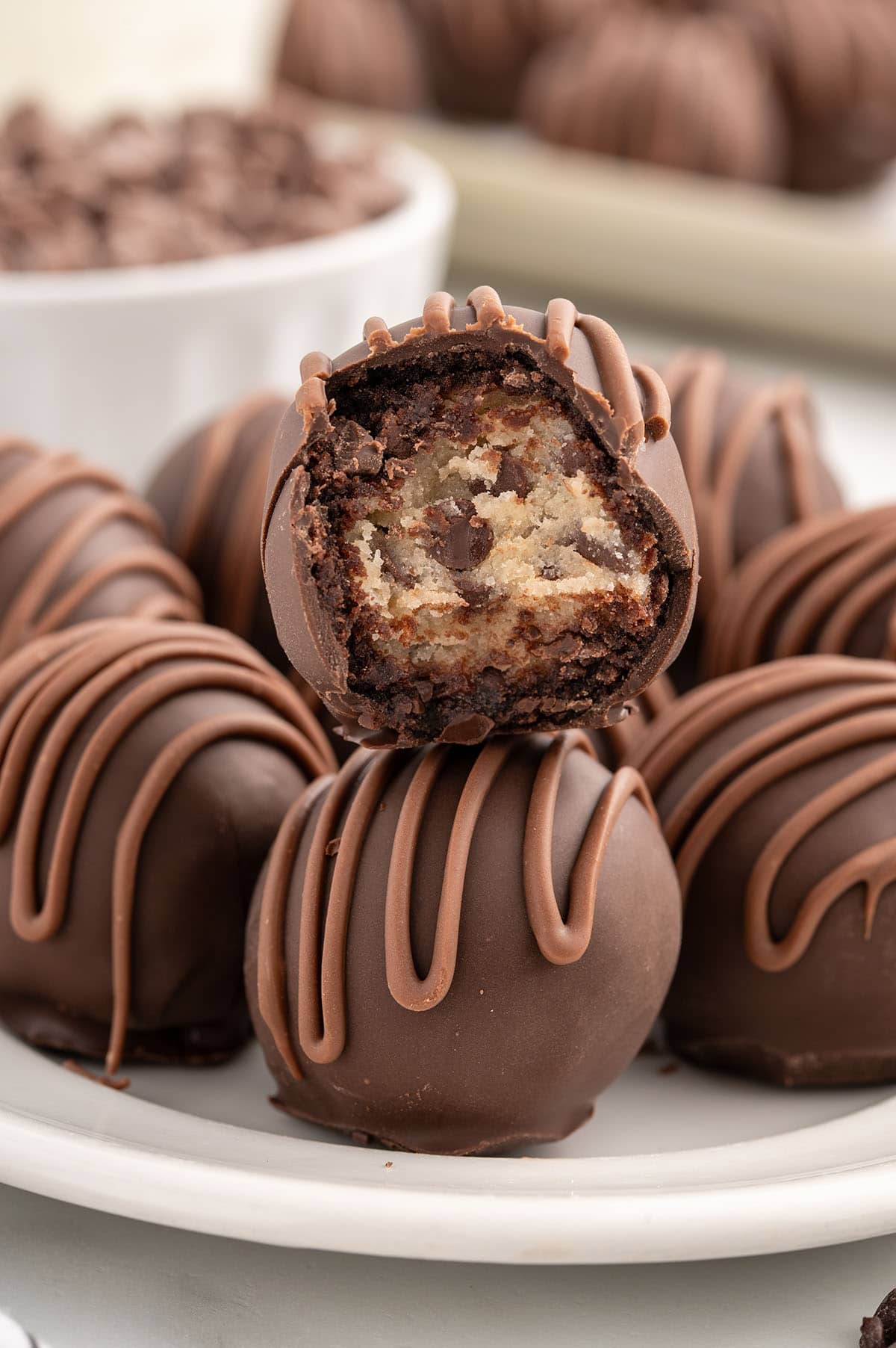 Chocolate chip cookie dough brownie bombs on a plate, one with a bite taken out.