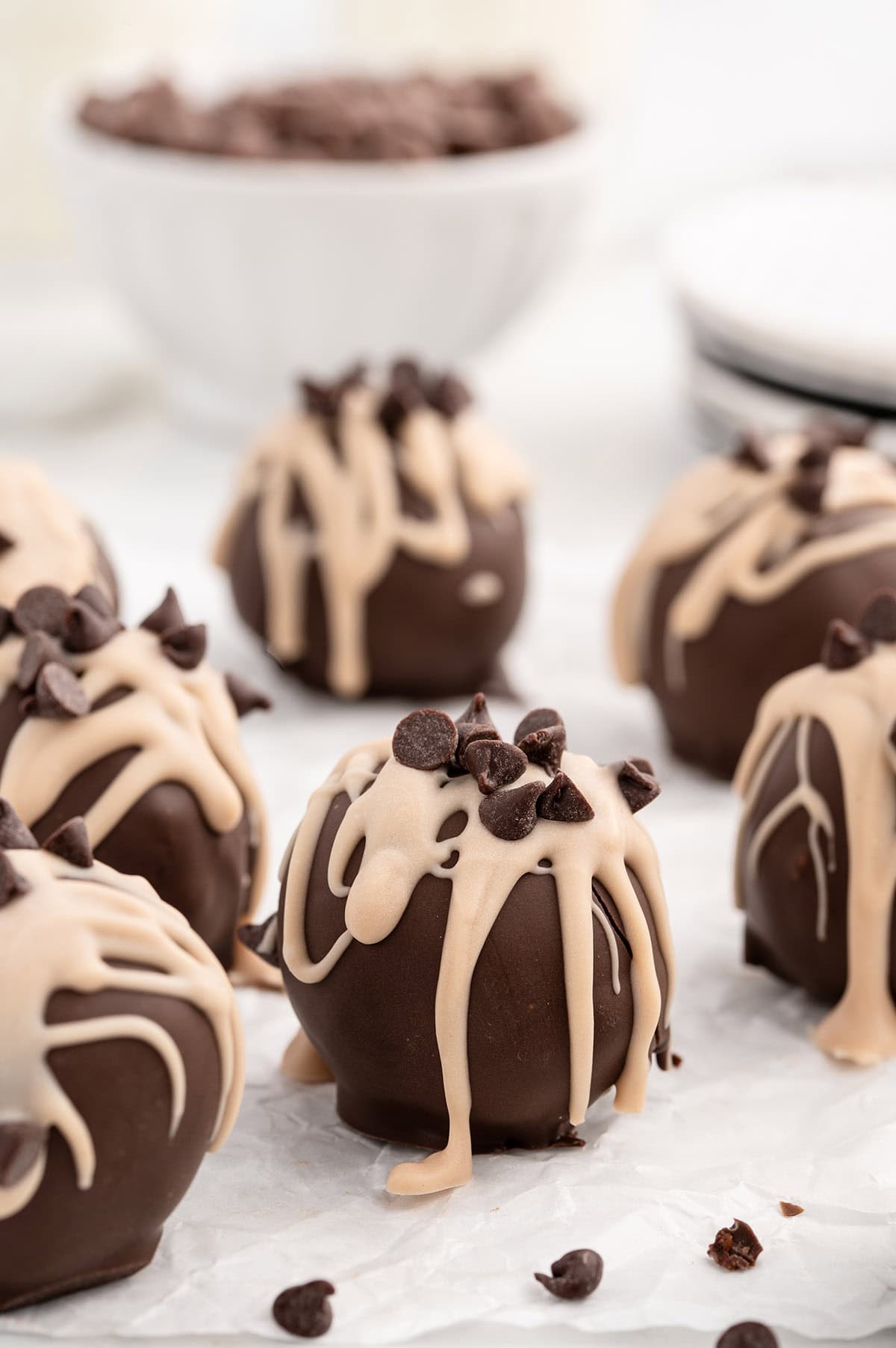 Chocolate chip cookie dough brownie bombs drizzled with peanut butter and topped with chocolate chips.