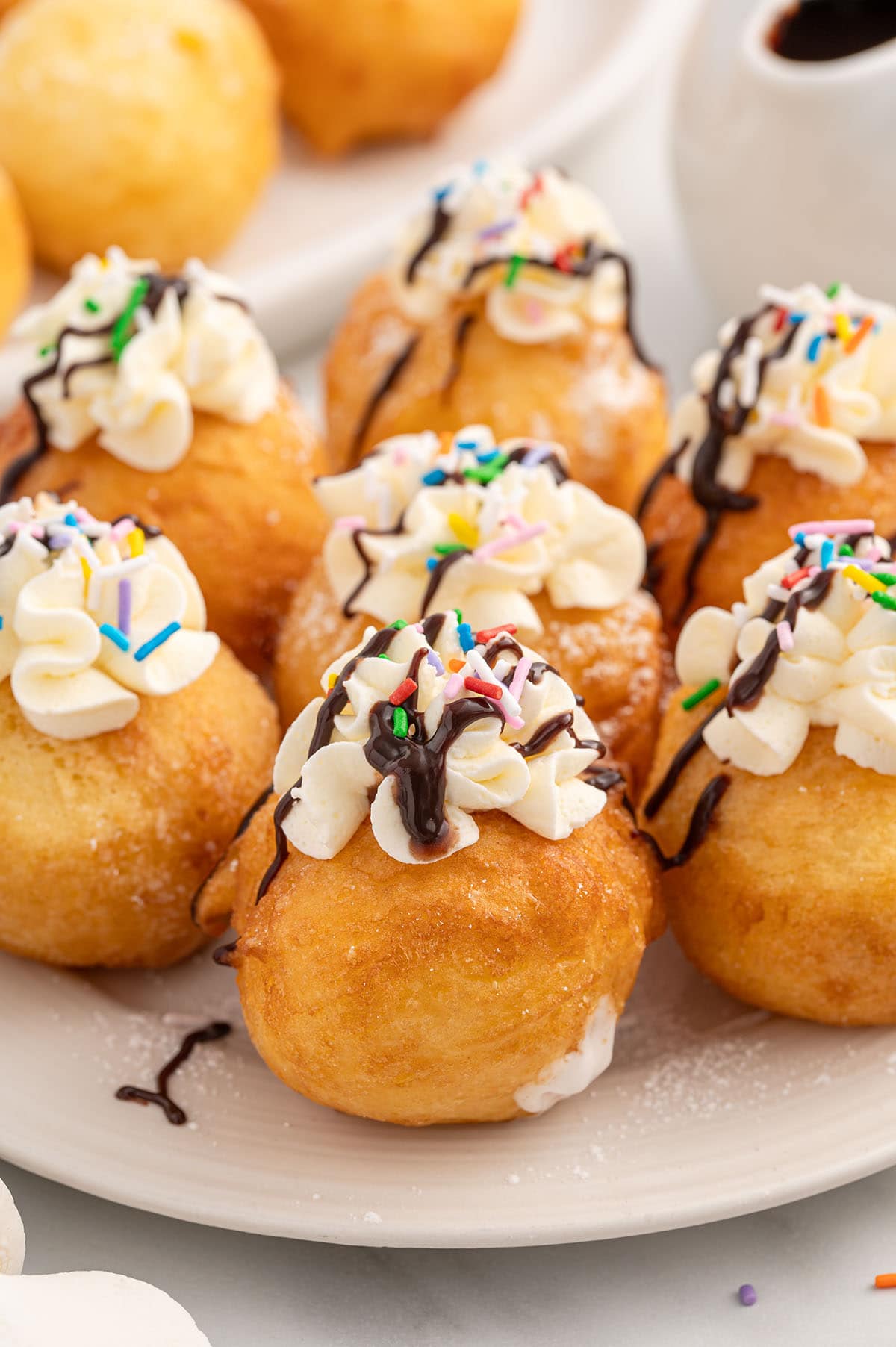 deep fried marshmallow topped with whipped topping and sprinkles. 