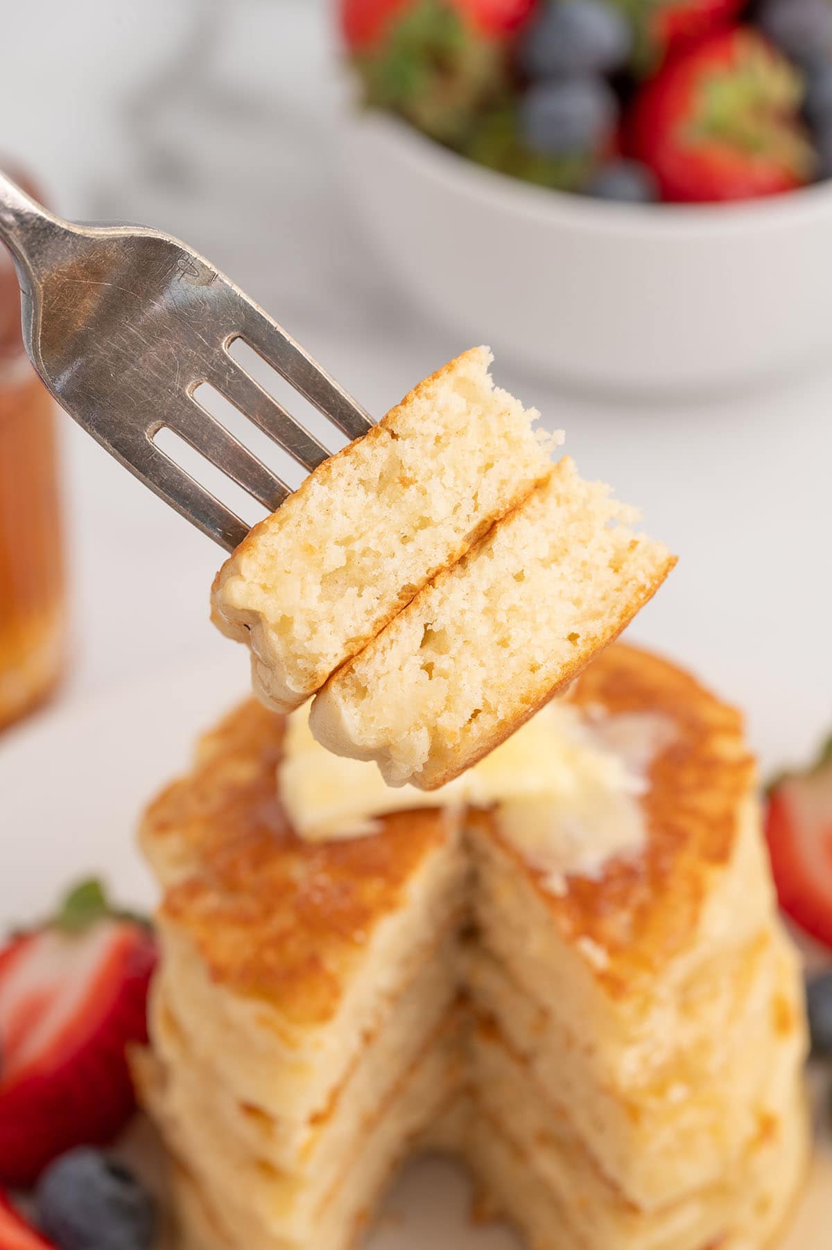 Bite of fluffy pancake on a fork.