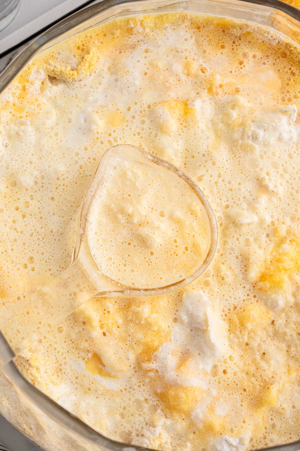 Ladle scooping Orange Dreamsicle Punch from a bowl.