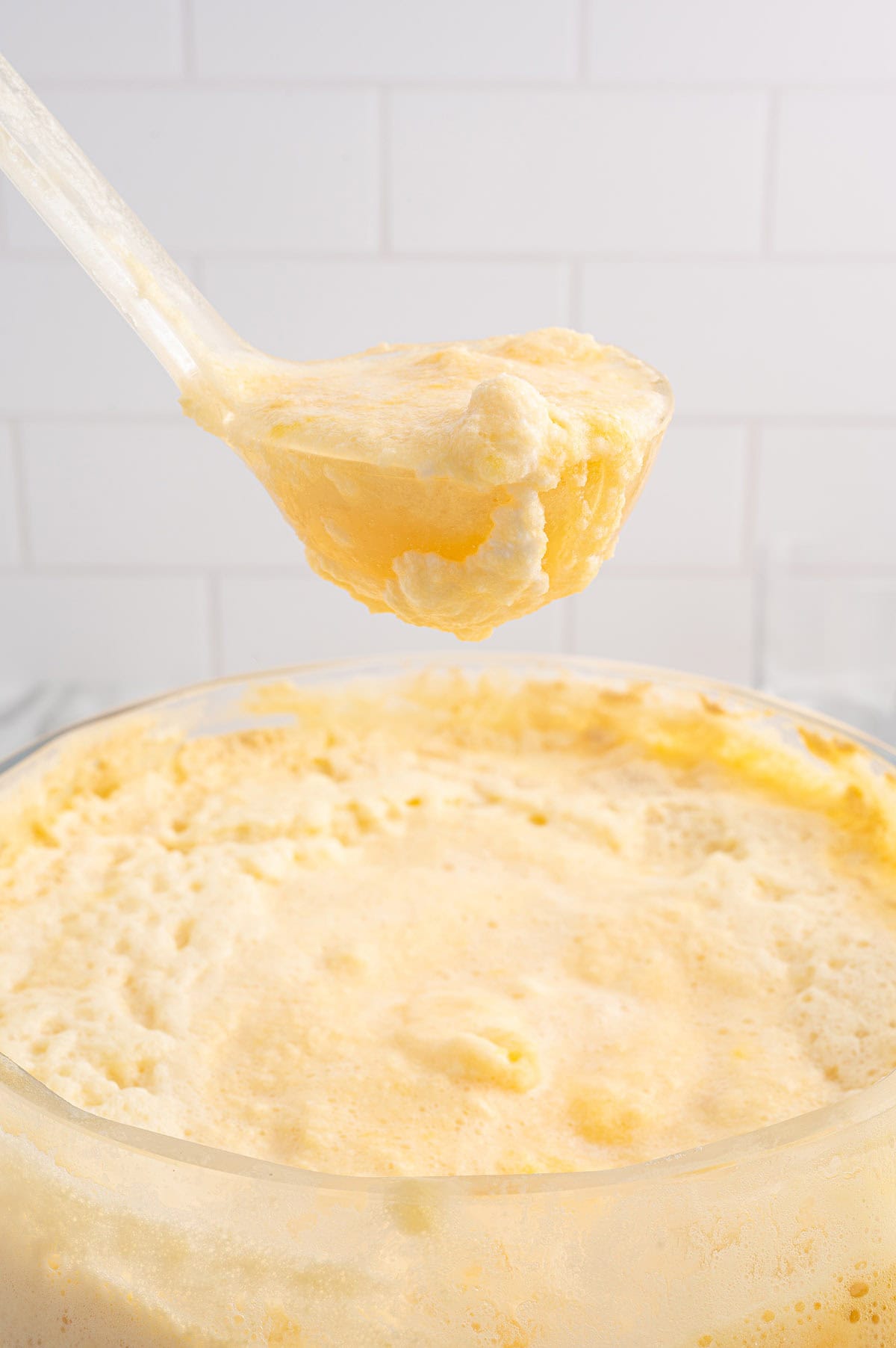 Ladle lifting a scoop of Orange Dreamsicle Punch from the bowl.