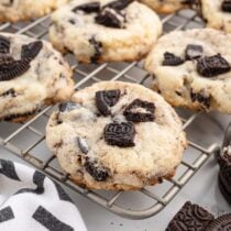 Oreo cheesecake cookies with chunks of Oreo on a cooling rack.