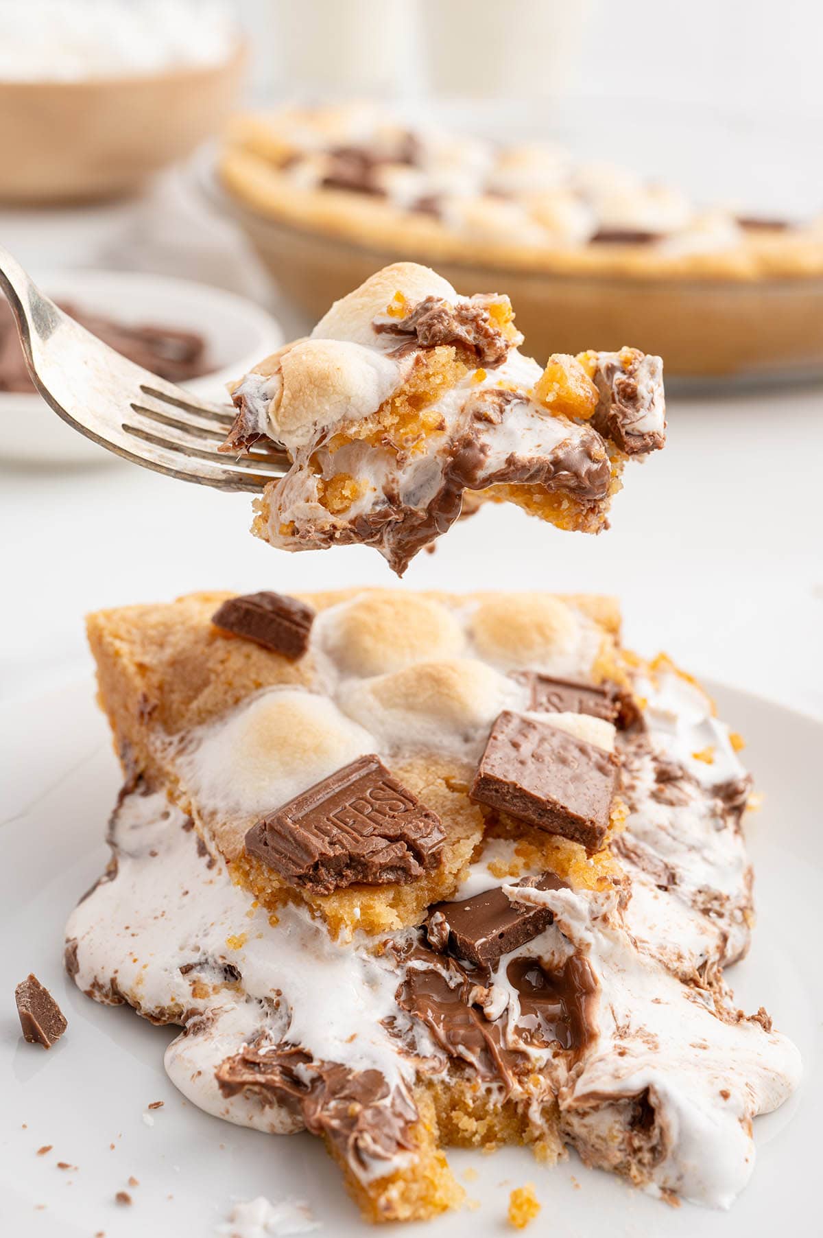 Forkful of gooey s'mores pie with melted chocolate and marshmallows.