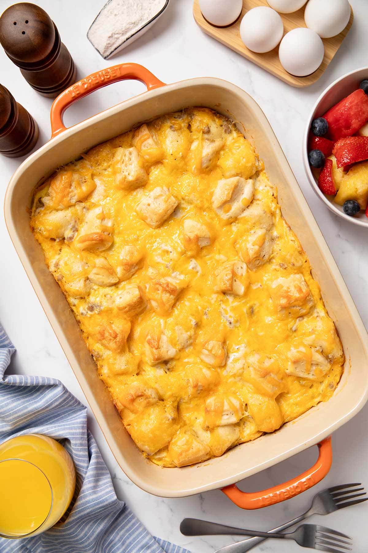 Biscuits and gravy casserole baked with eggs, sausage, and melted cheese in a casserole dish.