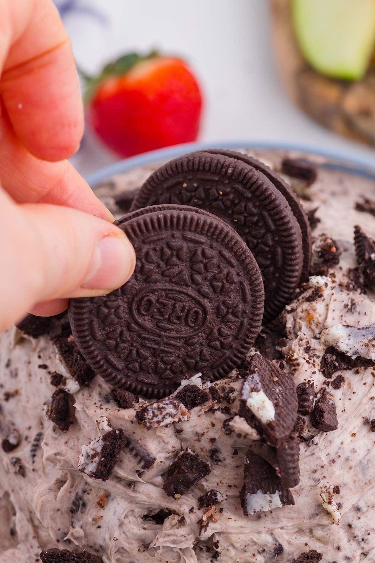 Dipping Oreo cookie into Oreo Dip.