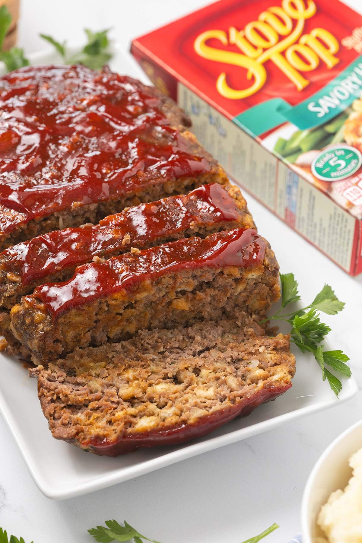 Stove Top Stuffing Meatloaf sliced on a plate with a ketchup glaze.